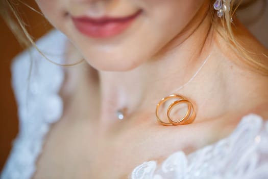 gold wedding rings in hands of newlyweds on wedding day