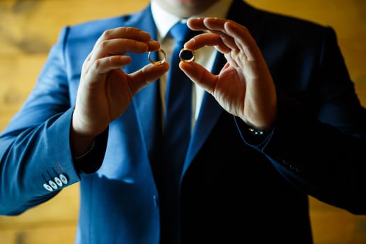 gold wedding rings in the hands of the newlyweds