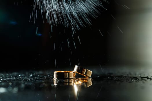 Gold wedding rings with water splashes