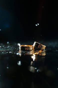 Gold wedding rings with water splashes