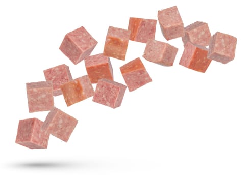 Flying sausage. Cubes of smoked sausage on a white isolated background. Salami cubes fall on a white background, for insertion into a design or project