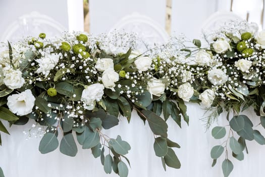 Beautiful wedding arch of flowers for the newlyweds. Decoration on a holiday