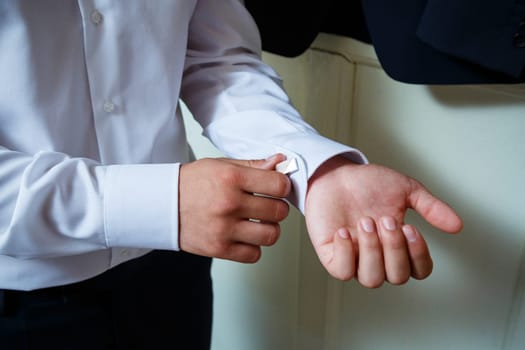 A man puts on a men's suit on the day of the wedding