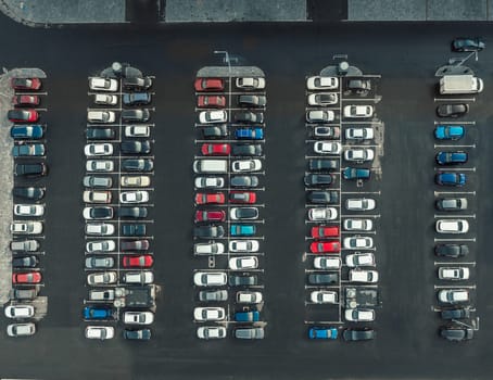 Drone top view of lot of cars parked on asphalt car park in city. Aerial top down view, many cars are parked