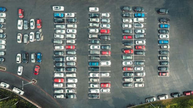 Drone top view of lot of cars parked on asphalt car park in city. Aerial top down view, many cars are parked