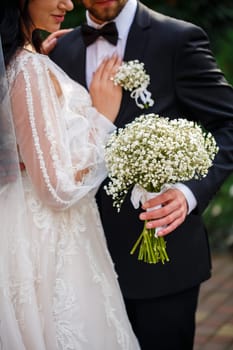 Wedding bouquet with fresh natural flowers in the hands of the bride