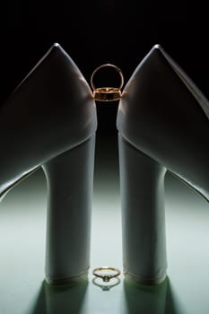 Gold wedding ring with women's shoes on the wedding day