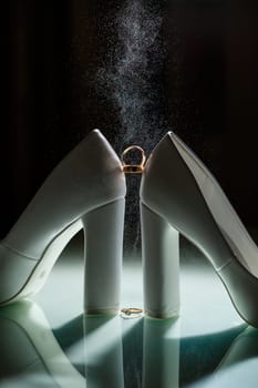 Gold wedding ring with women's shoes on the wedding day