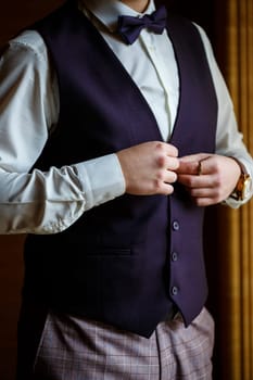 Man puts on a wedding suit and accessories on the wedding day.