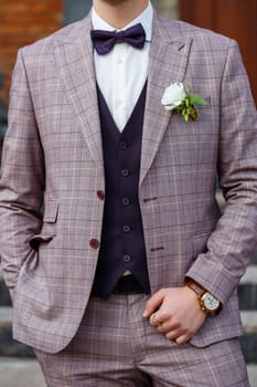 Man puts on a wedding suit and accessories on the wedding day.