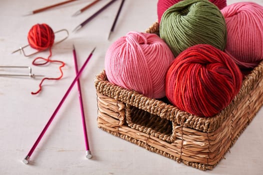 Knitting needles and skeins of yarn in basket