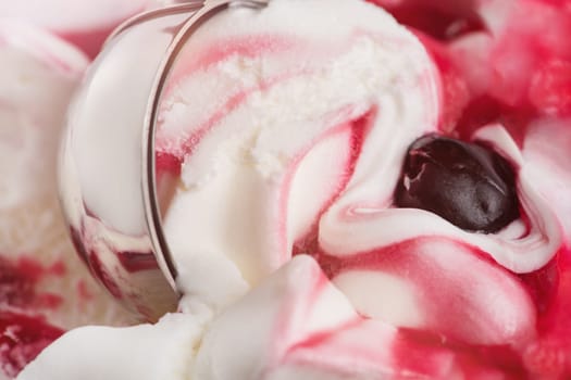 Texture of cherry ice cream. An ice cream spoon is inserted into an ice cream with a cherry in a cup. Ice cream closeup. The concept of treats for children and adults