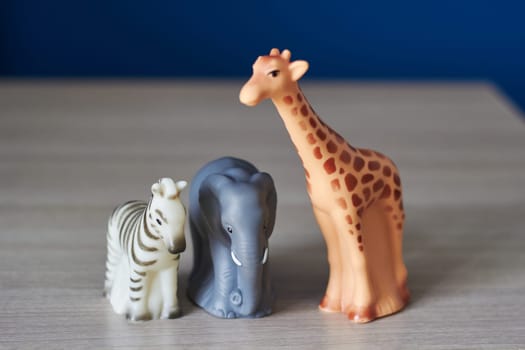 Photo of rubber children's toys on table. Zebra, elephant and giraffe. Entertainment. Children's games.