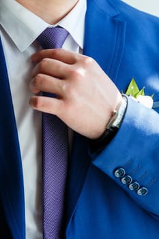 A man puts on a men's suit on the day of the wedding