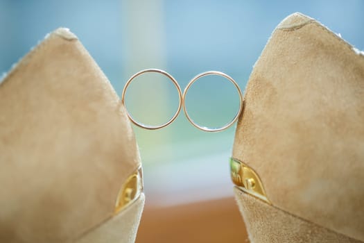 Gold wedding ring with women's shoes on the wedding day
