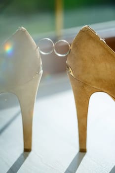 Gold wedding ring with women's shoes on the wedding day