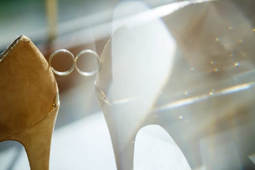 Gold wedding ring with women's shoes on the wedding day