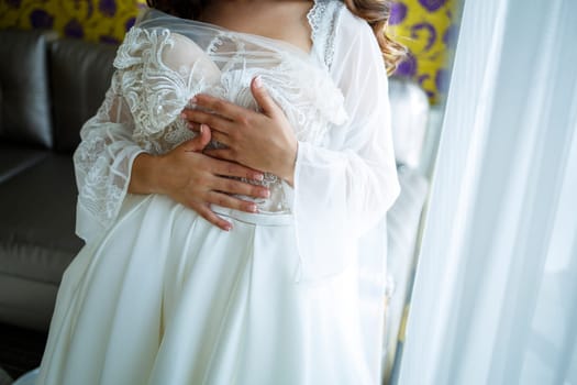 the bride holds in her hands a beautiful wedding dress