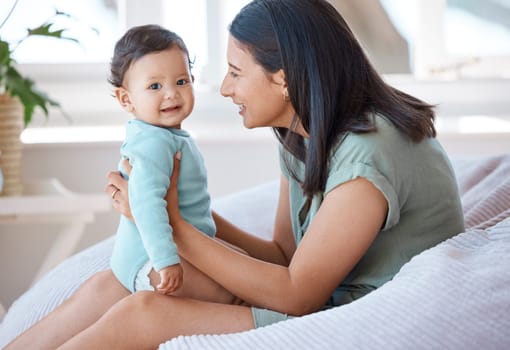 Happy, mother and holding with baby on lap in home for love, care and quality time together for play, growth and development. Mom, infant and bond with newborn girl kid on bean bag in nursery room.