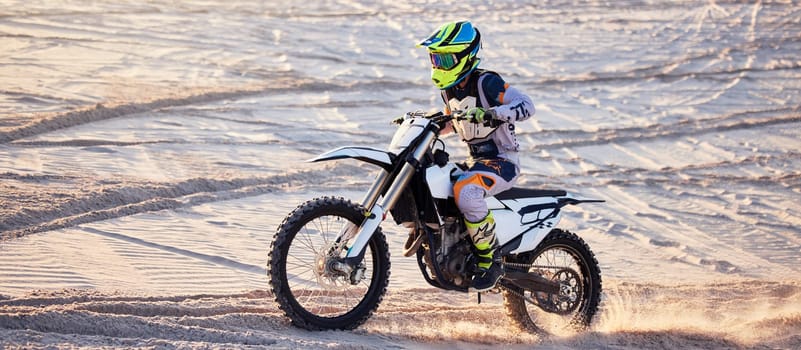 Motorcycle, desert race and extreme sport expert with agile speed, power or balance in nature. Motorbike man, rally and sand on fast vehicle with helmet, safety clothes and motivation for motorsport.