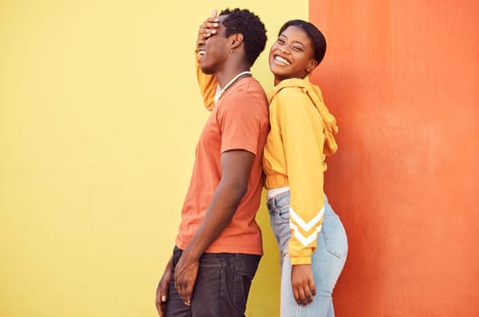 Fashion portrait, people or couple of African friends relax with designer brand clothes, casual style and luxury apparel. Urban gen z aesthetic, black woman and man on orange yellow background wall.