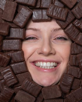 Face of caucasian woman surrounded by chocolates