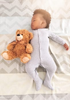 Teddy bear, bed and baby sleeping in home with lens flare for rest, nap time and dreaming in nursery. Childcare, newborn and cute, tired and African child in bedroom sleep for comfort, relax and calm.