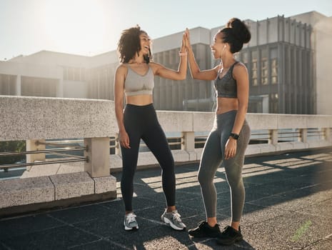 Fitness, friends and high five in the city for workout, exercise or healthy training together in the outdoors. Happy women touching hands in partnership for sports wellness, exercising or run in town.