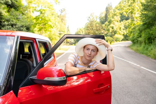 Photo of positive cheerful girl funky driver rider enjoy drive ride car under pop star hits playlist music try dance raise hands in city center