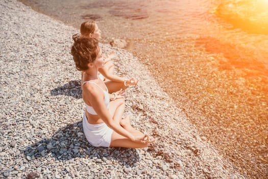 Woman sea yoga. Back view of free calm happy satisfied woman with long hair standing on top rock with yoga position against of sky by the sea. Healthy lifestyle outdoors in nature, fitness concept.