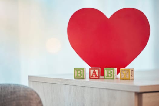 Heart, sign and baby toy announcement for a kid, child or newborn on a family home table. Love, care and announce or notification in wooden building blocks design for colourful news with a shape.