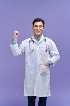Young handsome man wearing doctor uniform and stethoscope pointing thumb up to the side 