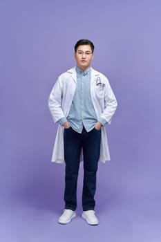 Portrait of male confident doctor over purple background studio, healthcare and Medical technology concept.