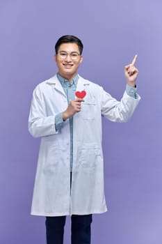Male doctor man wear white medical gown suit work, show red paper heart mockup point finger