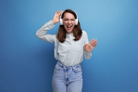 young brown-haired woman rips off to music from wireless headphones.