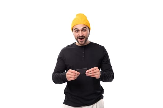 smart authentic brunet male adult in a black sweater talks about an idea on a white background with copy space.