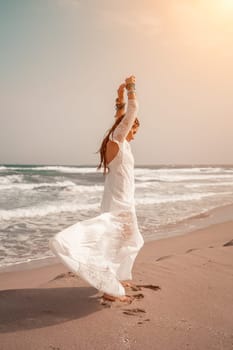 woman sea white dress. Model in boho style in a white long dress and silver jewelry on the beach. Her hair is braided, and there are many bracelets on her arms