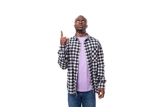 smart young american man in a plaid shirt is inspired by an idea and holds a thumbs up.