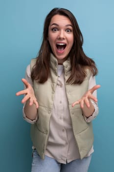 surprised brunette young woman with open mouth on studio background.