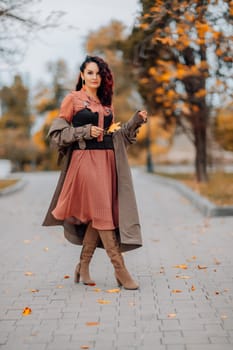 A woman walks outdoors in autumn, enjoys the autumn weather