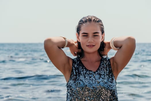 Woman travel sea. Young Happy woman in a long red dress posing on a beach near the sea on background of volcanic rocks, like in Iceland, sharing travel adventure journey