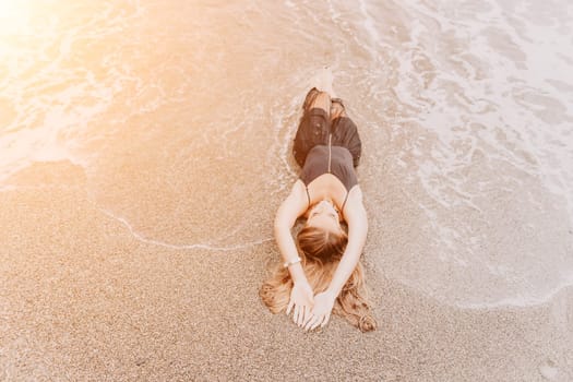 Woman travel sea. Young Happy woman in a long red dress posing on a beach near the sea on background of volcanic rocks, like in Iceland, sharing travel adventure journey