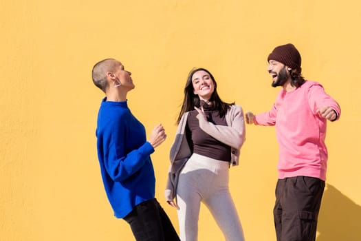 cheerful group of three friends dancing and having fun together, concept of friendship and happiness, copy space for text