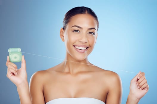 Floss product, dental portrait and woman on studio mockup for teeth, mouth cleaning and marketing. Happy female model, flossing thread and blue background for tooth cosmetics, wellness and healthcare.