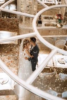 bride and groom inside a cocktail bar in a bright atmosphere with a glass of drink