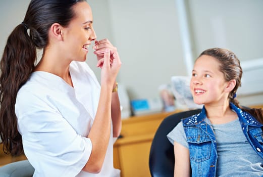 Technique is everything with flossing. a female dentist and child in a dentist office