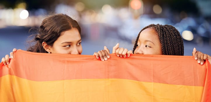 Rainbow flag, LGBTQ and happy lesbian couple with love at a freedom, pride or community parade in the city. Celebration, interracial and gay women with commitment at a LGBT sexuality event in town