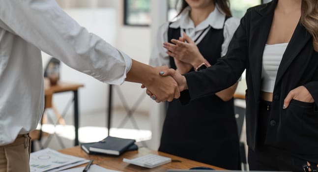 Businesspeople shaking hands finishing up meeting or negotiation in office. Business handshake and partnership.