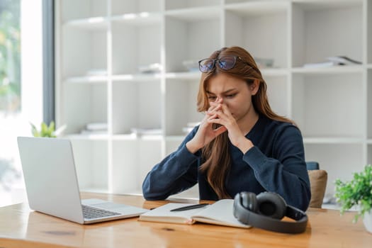 Laptop, stress and learning with a student woman feeling burnout while studying alone in her home. Education, headache and tired with a young female university or college pupil in her house to study.