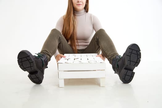 Female winter, autumn or spring black leather shoes on leg of woman in studio on white background. Fashionable modern photography and photoshoot for store, catalog, magazine or online